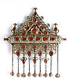 Amulet Holder, Silver; fire-gilded and chased, with decorative wire, ram’s-head terminals, openwork, slightly domed cabochon and table-cut carnelians, turquoise beads, wire chains, and spherical bells